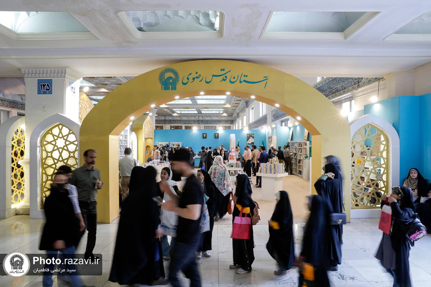 درست نبش راهروی یک، فضایی متفاوت،  نگاه هر بیننده ای را حتی از دور به سوی خود می‌کشاند. نگاهت به سمت آن غرفه بزرگِ سر نبش که افتاد و نزدیکتر شدی، نمی‌دانی چه چیزی دلت را هم می‌برد و هوایی‌ات می‌کند به قدم زدن در هوایش؛ سردرها و ورودی‌های قوسی‌شکل طلایی و پنجره‌های مشبکی اش یا عطر آشنای بهشتی که فضایش را پر کرده، یا یک حس شیرین ناشناخته که نمی‌شناسی‌اش اما آن را از سایر غرفه‌‌ها متفاوت کرده، درست…