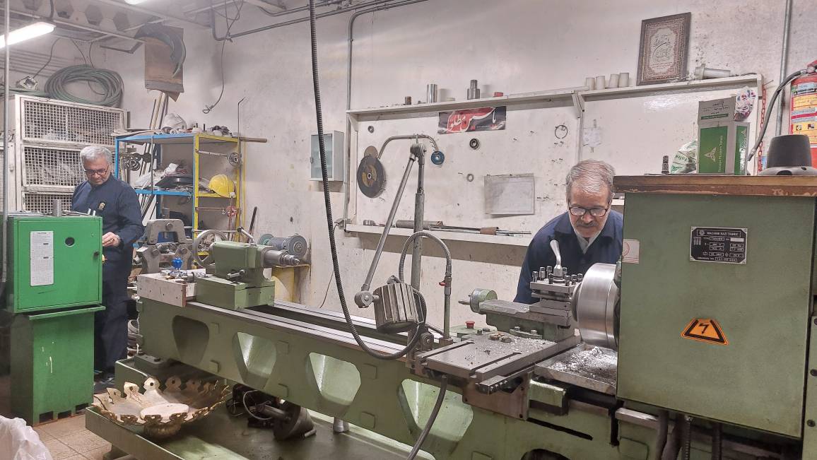 صداهای مختلف؛ از قیژ قیژ چرخ خیاطی تا صدای کوبیدن پُتک و چکش بر آهن و چوب، فضای مجموعه کارگاه‌های فنی حرم مطهر رضوی را پُر کرده است. هر کدام از مردان که لباس کار بر تن دارند، در کارگاهی مشغول فعالیت هستند. تابلوهایی مملو از نکات ایمنی همچون تابلوی «حادثه = بی‌دقتی + غرور»، بر روی دیوارها نصب شده است. اینجا در مکانی به دور از هیاهو و دلدادگی زائران و مجاوران در رواق‌ها و صحن‌های حرم مطهر، جمعی از…