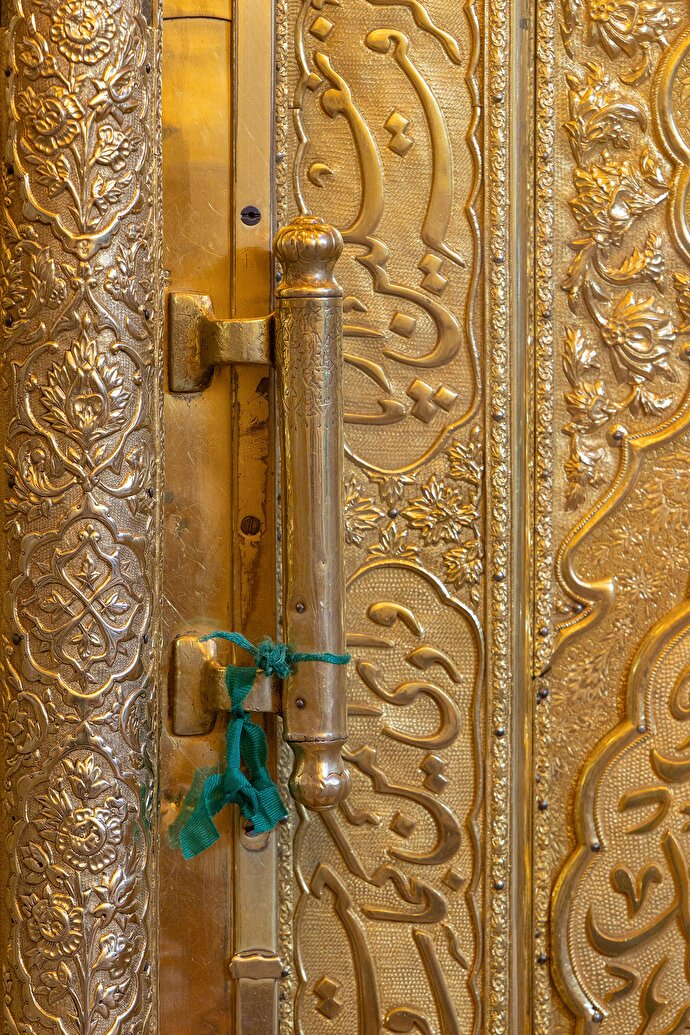 عکس با کیفیت: پارچه‌ای سبز، دخیلِ دلی بر درب ایوان طلای حرم امام رضا (علیه‌السلام)