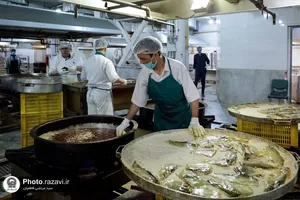 پخت و توزیع غذای متبرک ماهی سفره شب عید در مهمانسرای حضرت