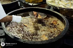 پخت و توزیع غذای متبرک ماهی سفره شب عید در مهمانسرای حضرت