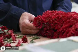 مشاهدة تزيين الزهور لعيد الغدير من خلف الواجهة الزجاجية للحرم الشریف