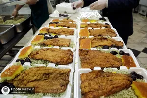 پخت و توزیع غذای متبرک ماهی سفره شب عید در مهمانسرای حضرت