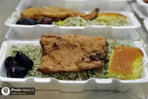 پخت و توزیع غذای متبرک ماهی سفره شب عید در مهمانسرای حضرت