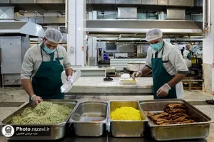 پخت و توزیع غذای متبرک ماهی سفره شب عید در مهمانسرای حضرت